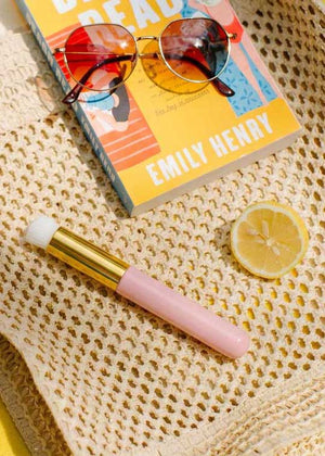 Luxury Lashes lash brush op gehaakte strandtas met zonnebril, citroen en zomerse beach setting.