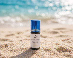 Luxury Lashes Soleil Glue voor wimperextensions op zandstrand met zeezicht en zomerse sunset sfeer.
