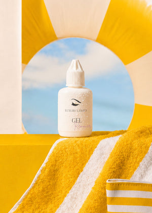 Luxury Lashes Gel Remover voor wimperextensions in zomerse beach setting met gele handdoek en zwembad sfeer.
